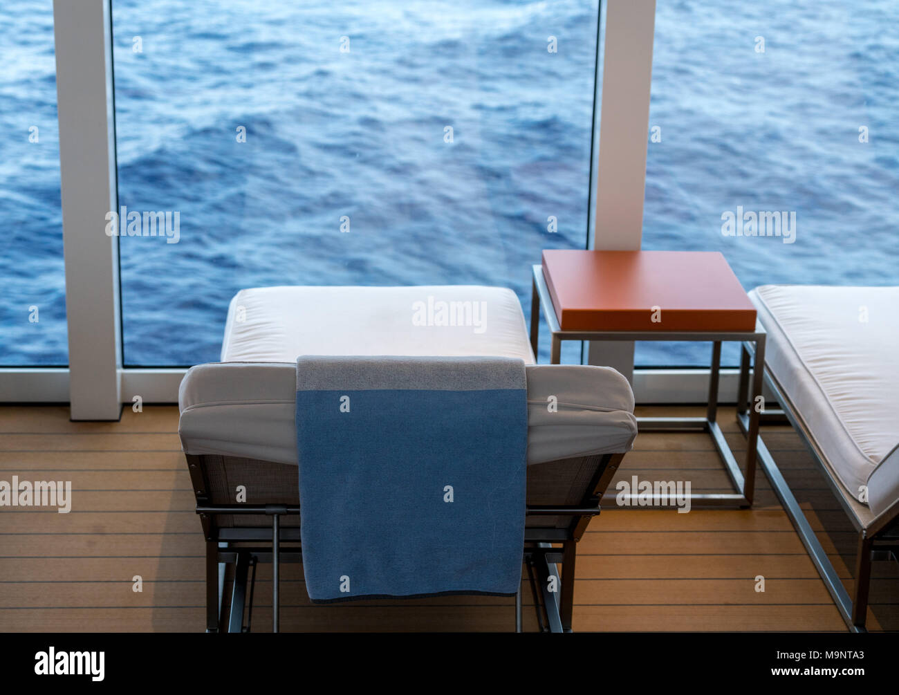 Cushioned lounger on cruise ship by ocean Stock Photo