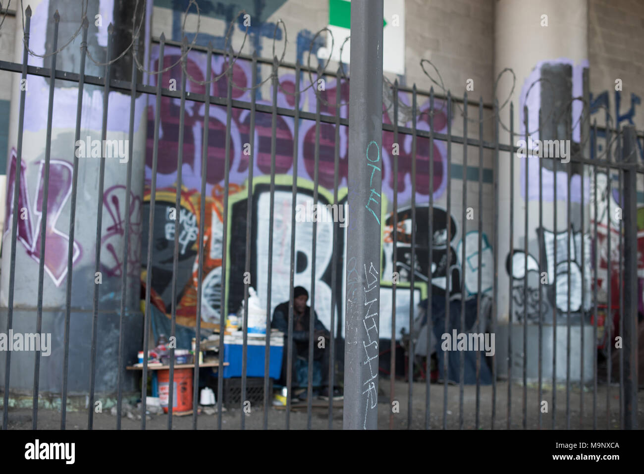 LOS ANGELES, CA - March 15, 2018: Unidentified homeless person sitting on the sidewalk under the bridge in Downtown of Los Angeles on March 15, 2018, Stock Photo