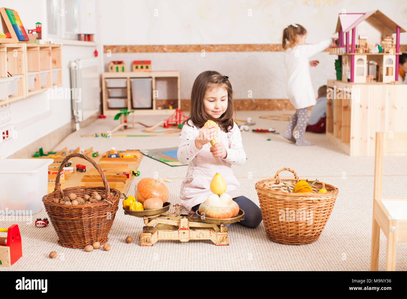 cute little girl is playing with scales Stock Photo