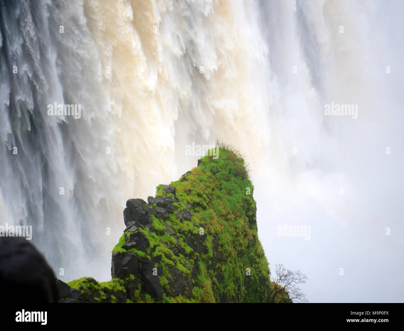 Millions of litres of Zambezi River water cascading down the Victoria Falls; Mosi-oa-Tunya, 'The Smoke that Thunders' on the Zambia Zimbabwe border Stock Photo