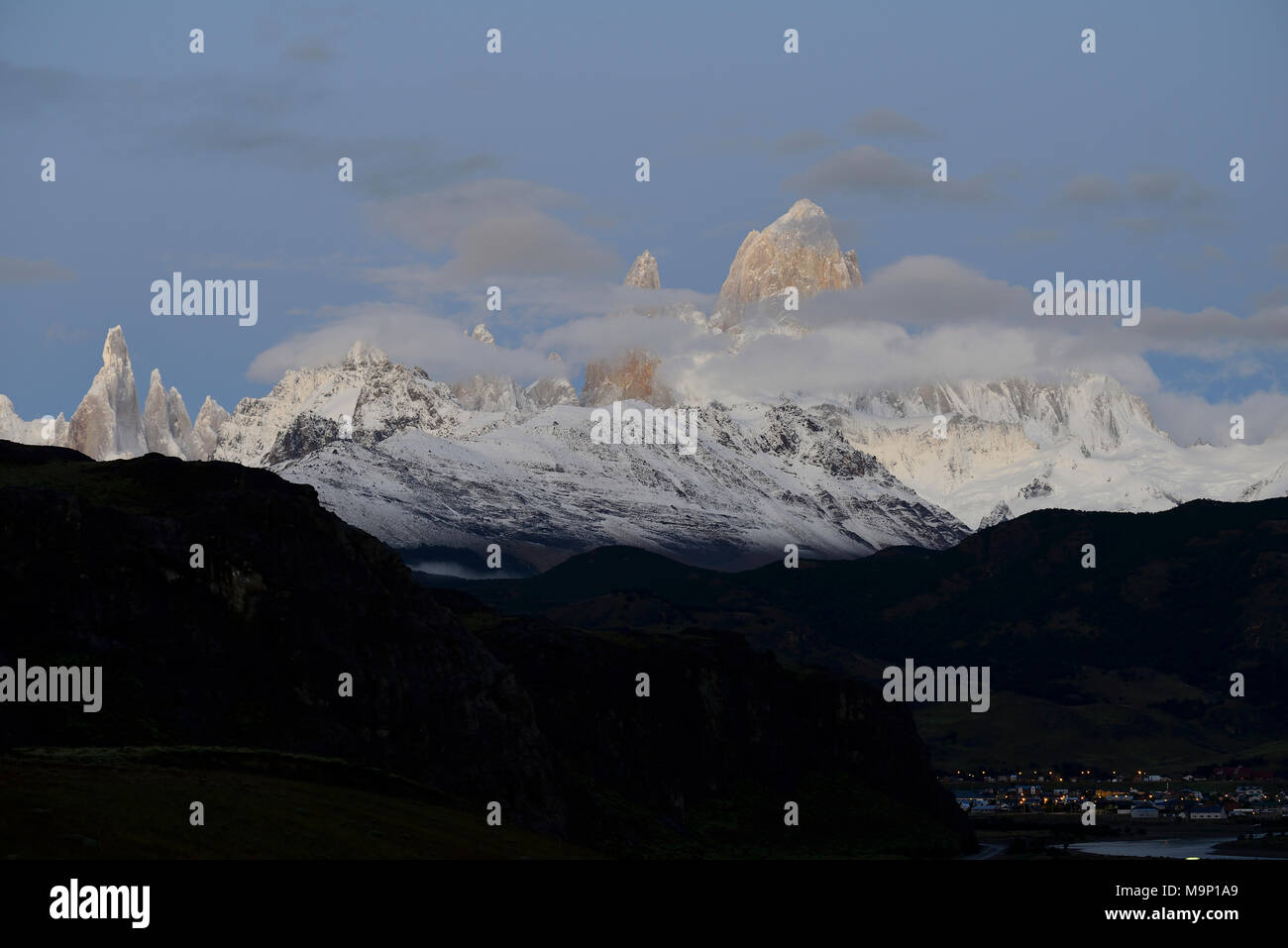 Snow-covered mountain range of the Fitz Roy and Cerro Torre with clouds at dawn, Los Glaciares National Park, El Chaltén Stock Photo