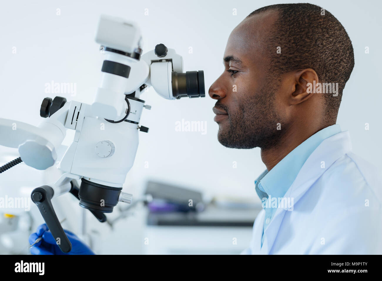 Side view of male dentist using microscope Stock Photo