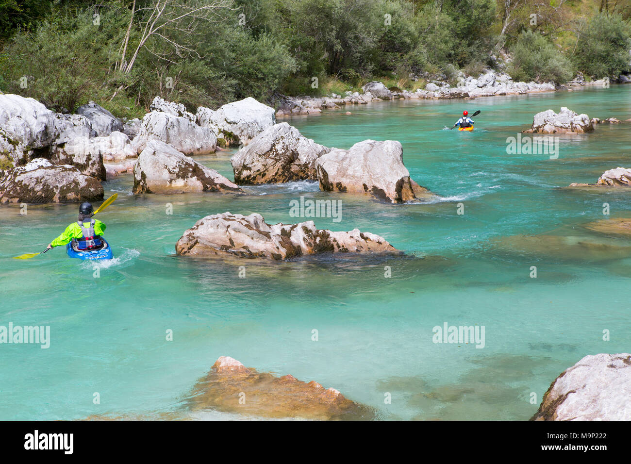 Two kayakers paddling on green colored Soca river near Bovec, Slovenia Stock Photo