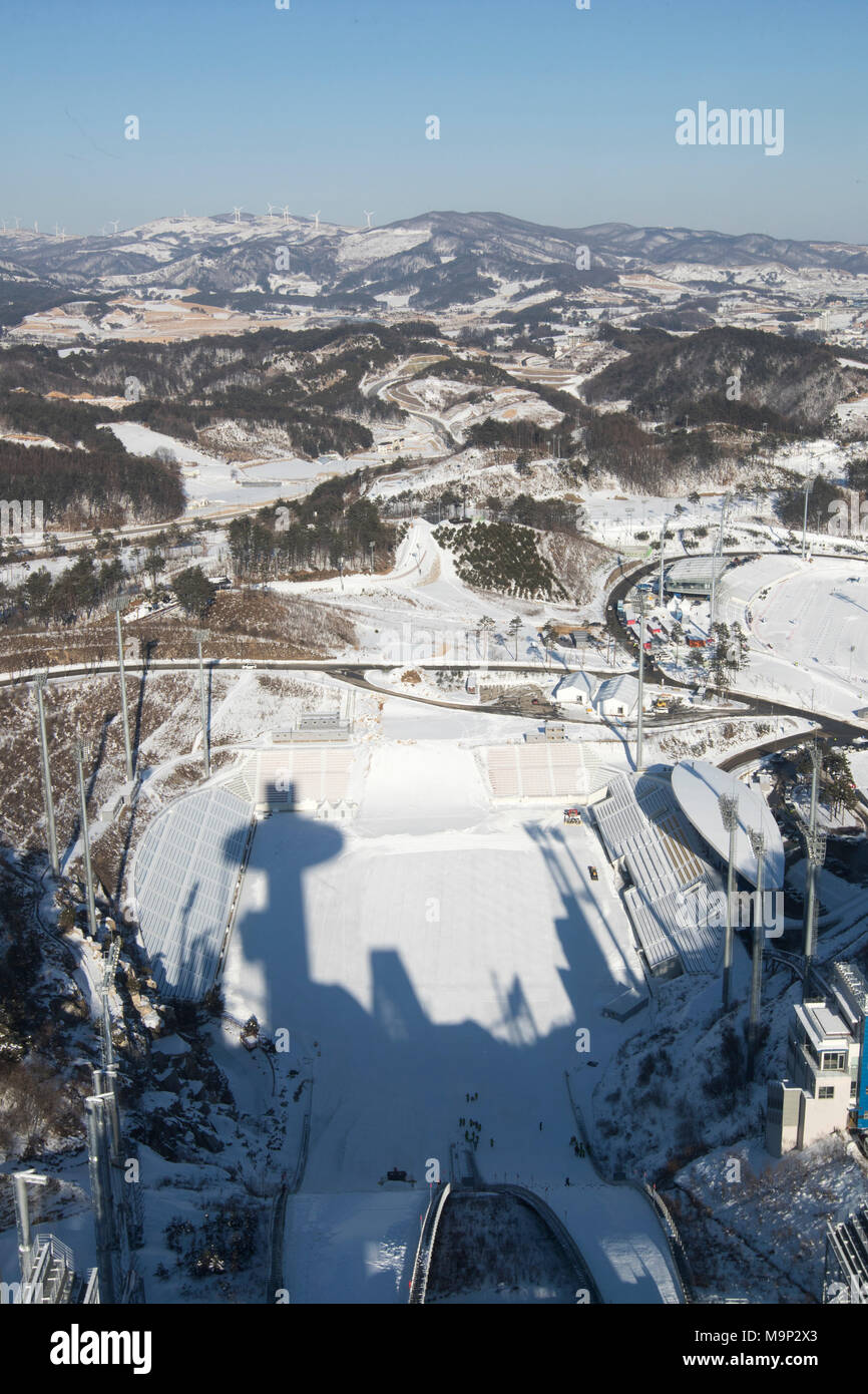 View from the top of the Olympic ski jumping tower.  Alpensia Ski Jumping Stadium is a multi-purpose stadium located at Alpensia Resort in Pyeongchang, South Korea. It will host ski jumping events during the 2018 Winter Olympics.   The Alpensia Resort is a ski resort and a tourist attraction. It is located on the territory of the township of Daegwallyeong-myeon, in the county of Pyeongchang, hosting the Winter Olympics in February 2018.  The ski resort is approximately 2.5 hours from Seoul or Incheon Airport by car, predominantly all motorway.   Alpensia has six slopes for skiing and Stock Photo