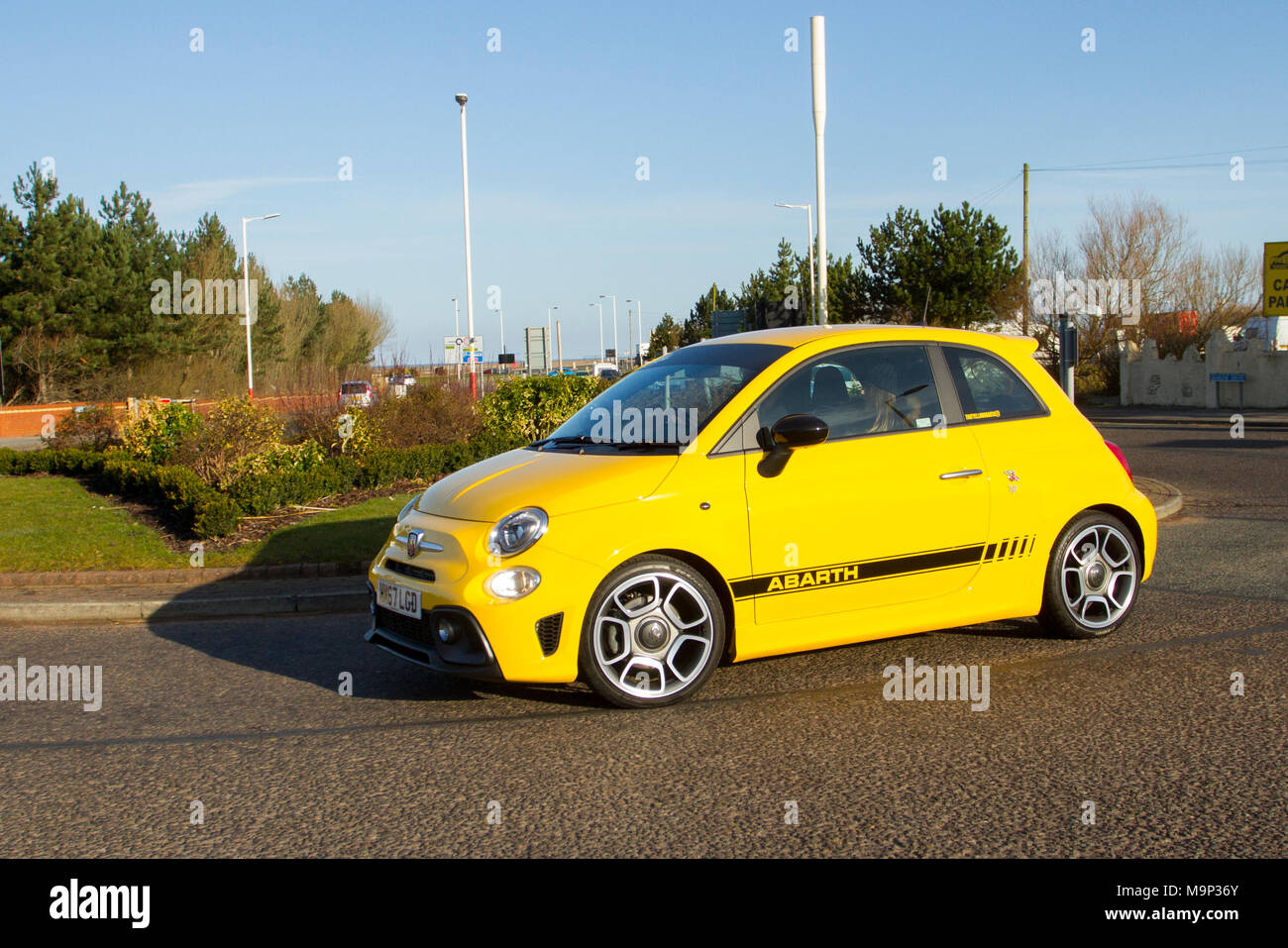 2018 yellow Abarth 2dr, two-door, four-passenger, transverse front-engine, front-wheel-drive saloon at the North-West Supercar event as  cars and tourists arrive in the coastal resort on a warm spring day. Abarth 595 cars are bumper to bumper on the seafront esplanade as classic & small car enthusiasts enjoy a motoring day out. Stock Photo