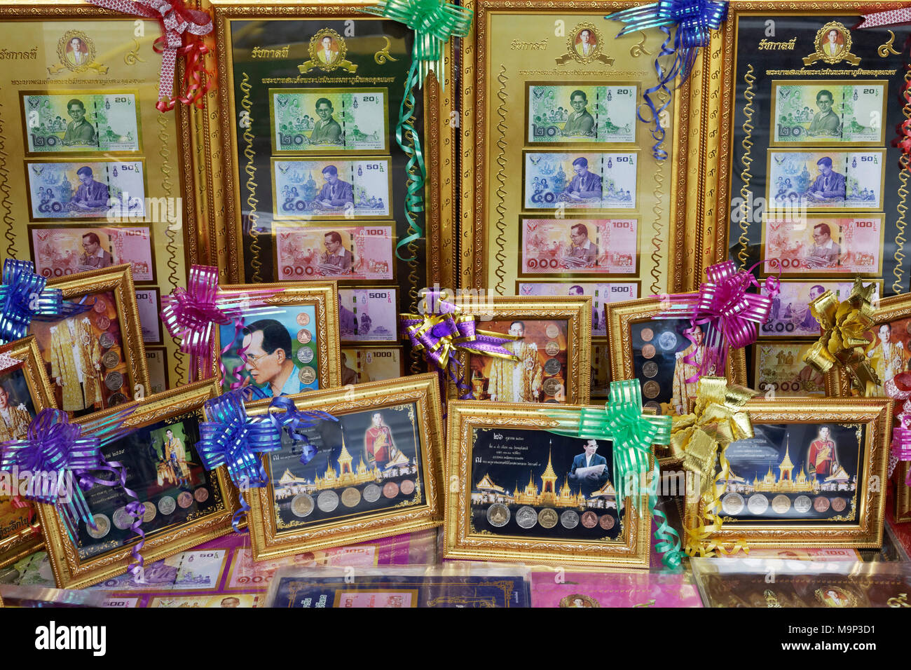 Former King Bhumibol Adulyadej on banknotes and coins, souvenirs in gold frame, Bangkok, Thailand Stock Photo