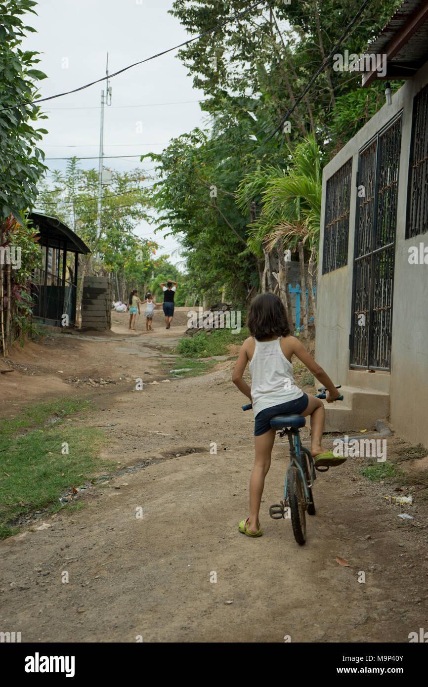 Girl on a bicycle in a poor neighbourhood of Managua, Nicaragua Stock Photo