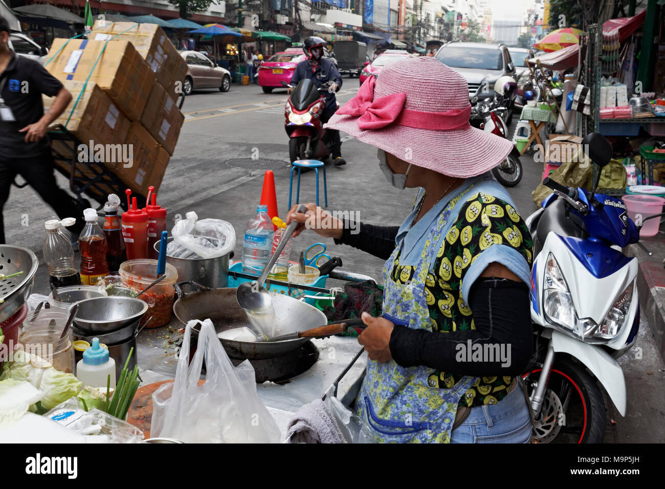 Cookshop, woman cooking at a streetfood stand, Yaowarat Road, Chinatown, Samphanthawong, Bangkok, Thailand Stock Photo