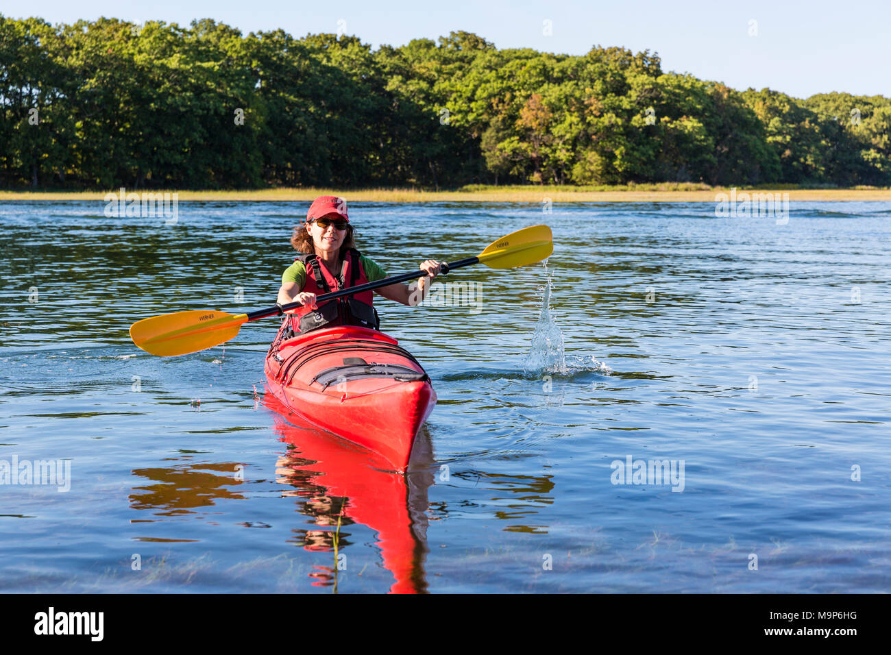 Woman in kayak on Essex River at Cox Reservation in Essex, Massachusetts Stock Photo
