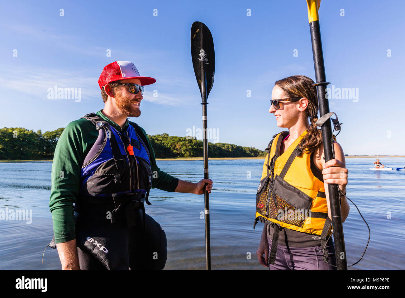 Couple taking break from kayaking on Essex River at Cox Reservation in Essex, Massachusetts Stock Photo