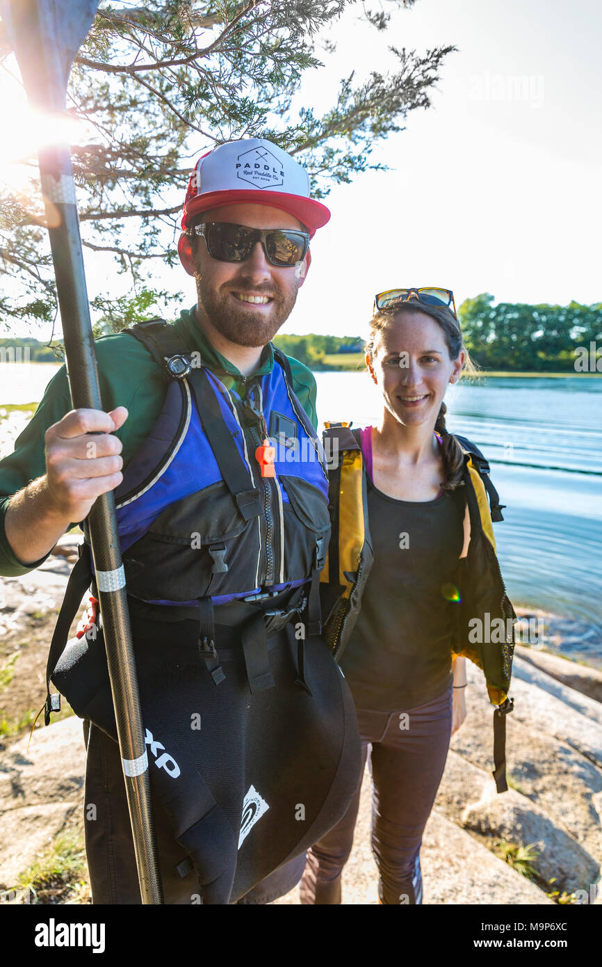 Couple taking break from kayaking on Essex River at Cox Reservation in Essex, Massachusetts. Stock Photo