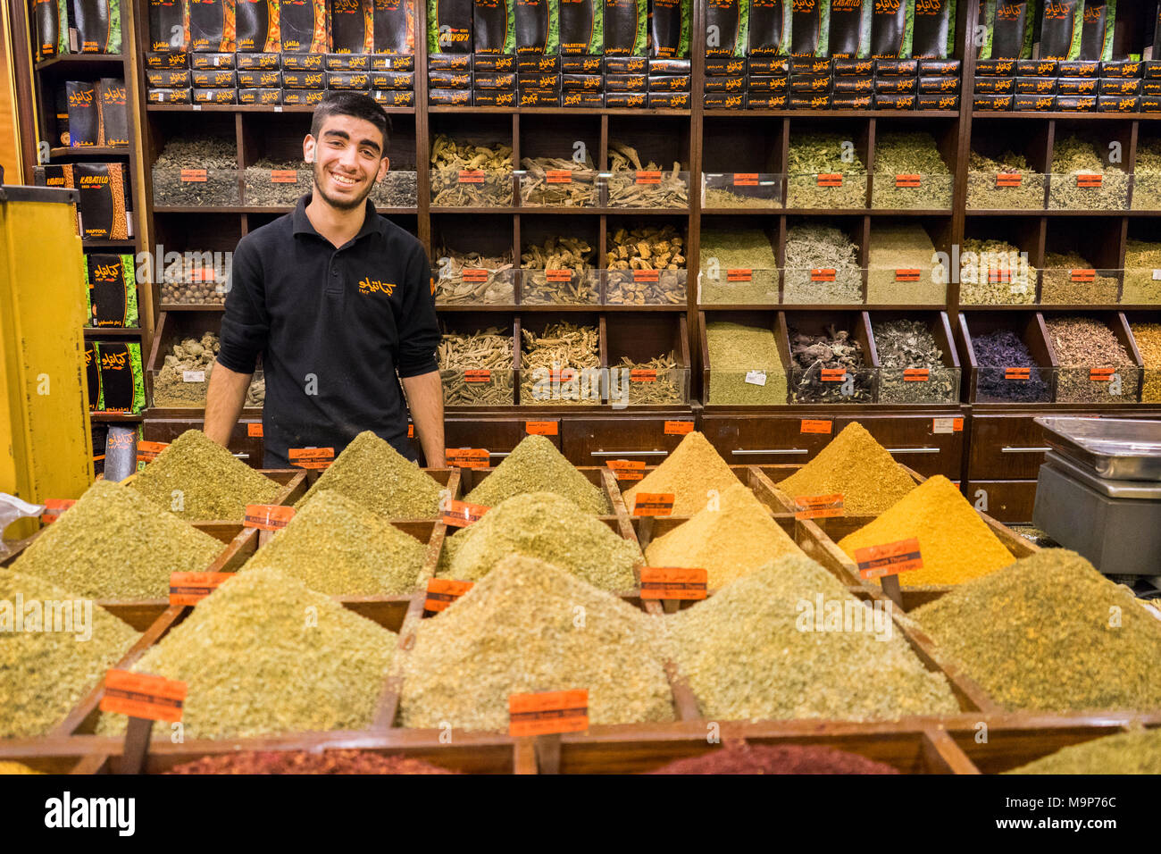 A man sells spices, herbs, nuts and Egyptian duqqa in a Spice Market in Amman, Jordan Stock Photo