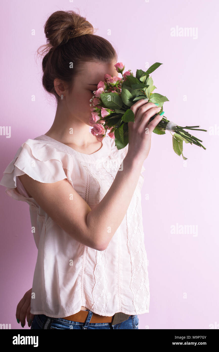 Woman sniffing a bouquet of roses Stock Photo