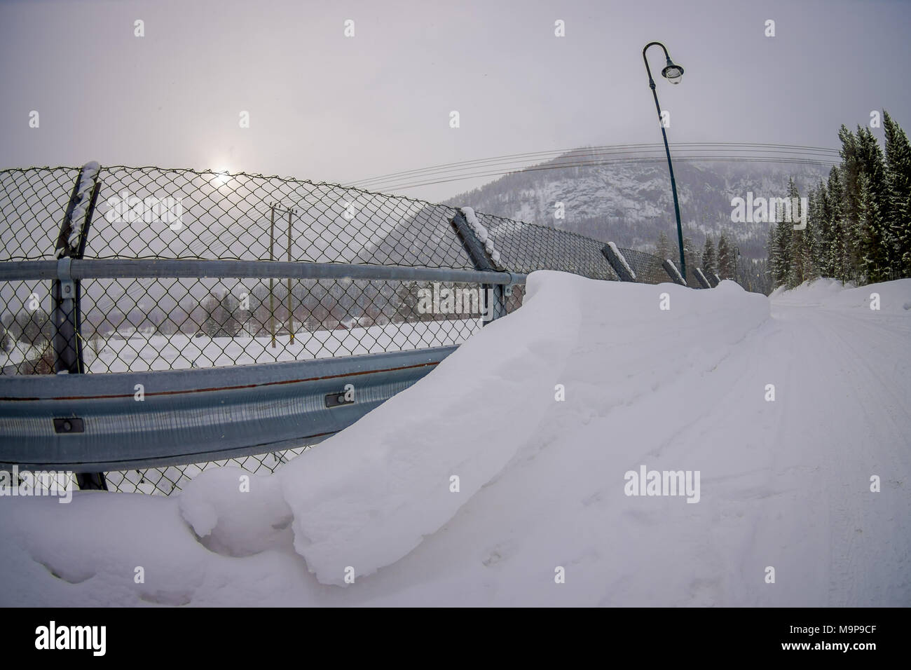 Outdoor view of metalllic structure protection close to water reservoir, with light lamps located at one side of the road in Hardangervidda in Norway Stock Photo