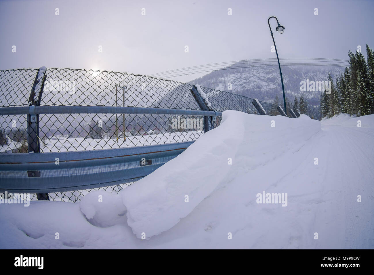 Outdoor view of metalllic structure protection close to water reservoir, with light lamps located at one side of the road in Hardangervidda in Norway Stock Photo