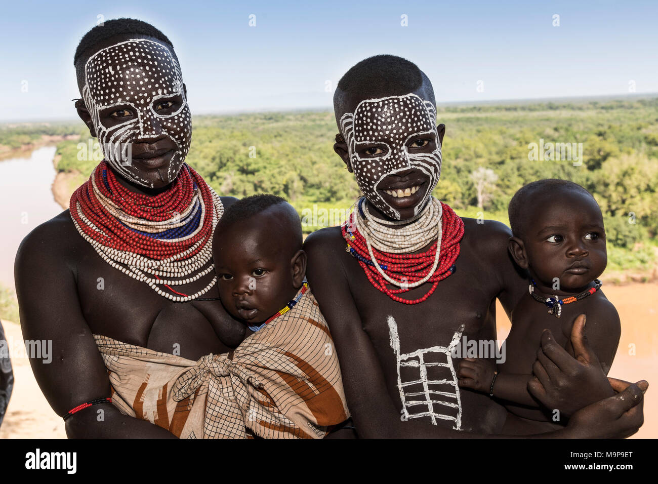 Two young women with babies and face painting, Karo tribe, behind Omo River, Southern Nations Nationalities and Peoples' Region Stock Photo