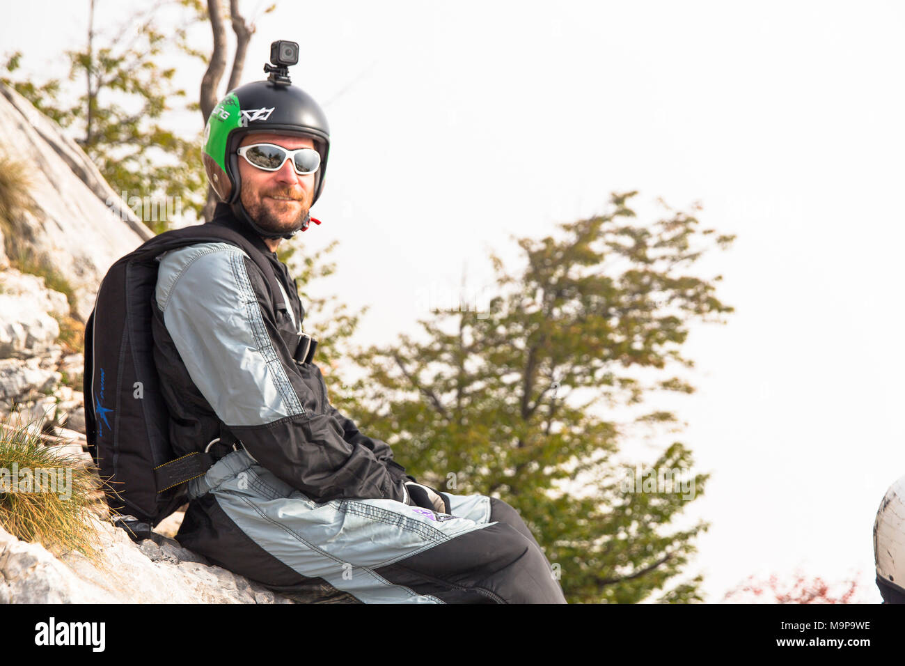 Male base jumper relaxing on rocks before jumping, Brento, Venetien, Italy Stock Photo