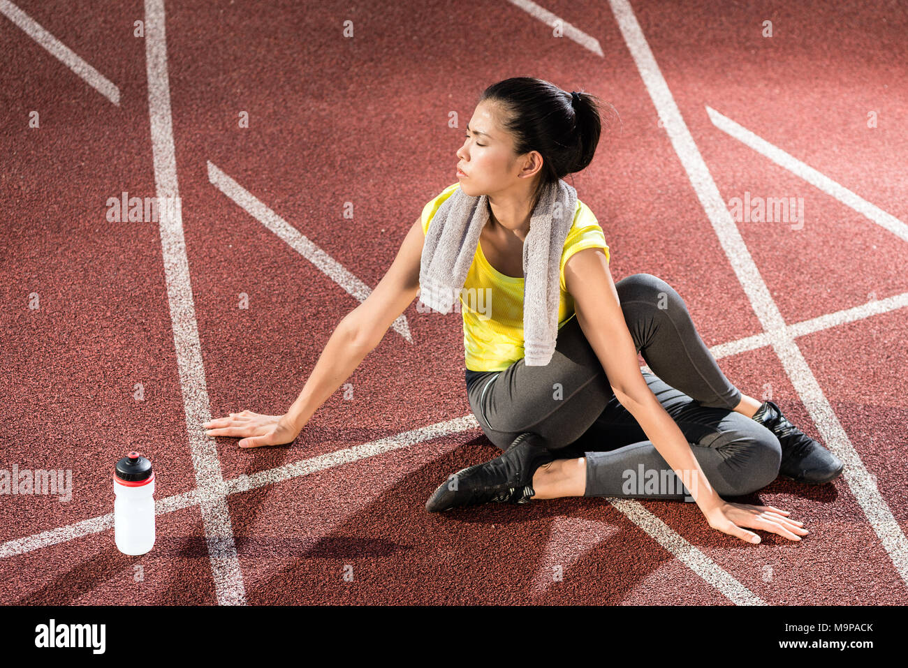 Woman sprinter doing warm up exercise before sprint Stock Photo