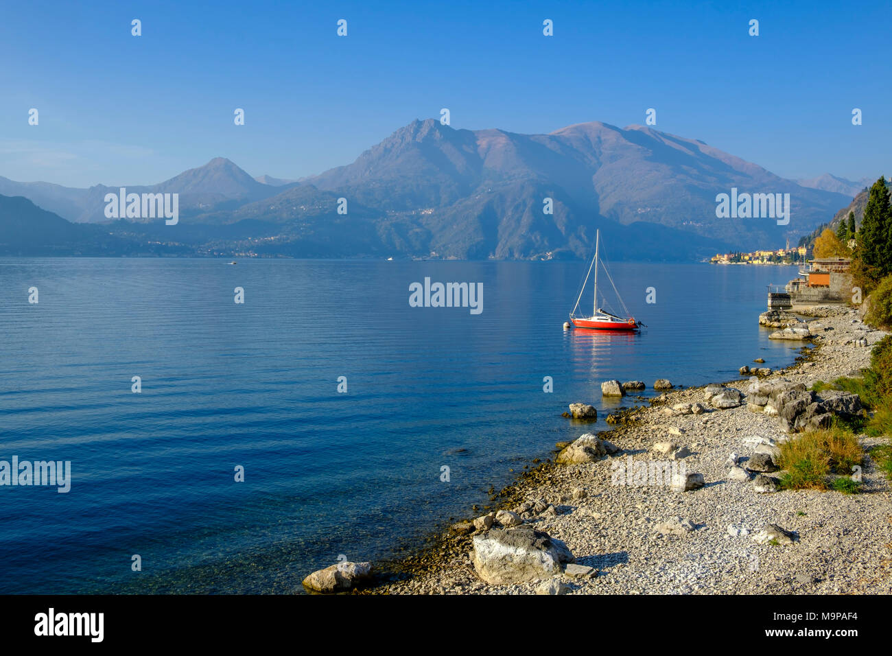 Red sailing boat on the shore, Lake Como, Varenna, Lago di Como, Lombardy, Italy Stock Photo