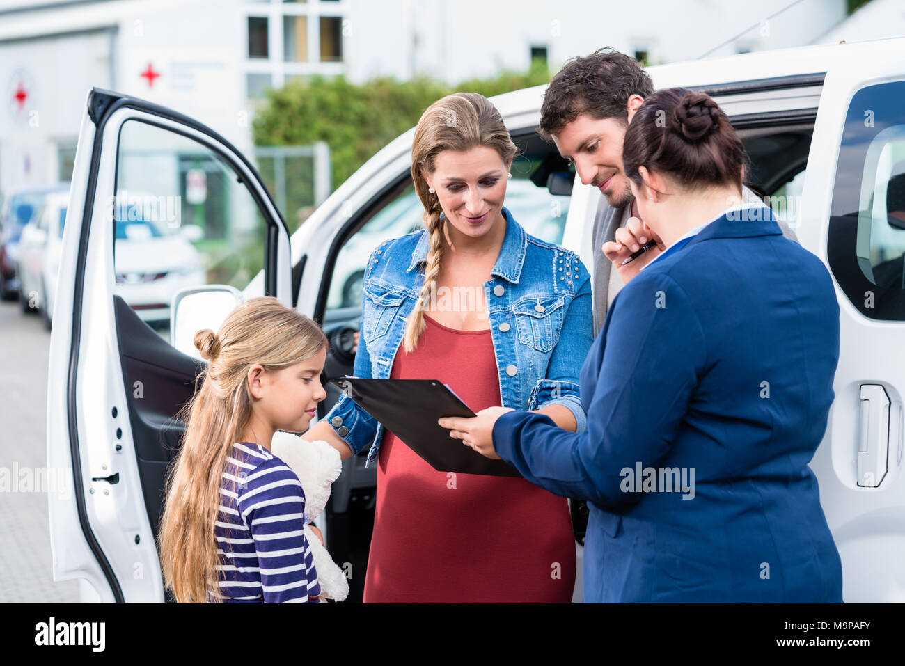 Family being advised by salesperson buying car Stock Photo