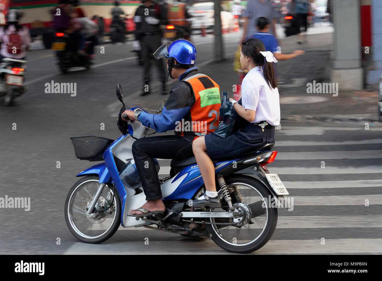 Scooter Taxi, driver with safety vest drives young girl, Sathon, Bangkok, Thailand Stock Photo