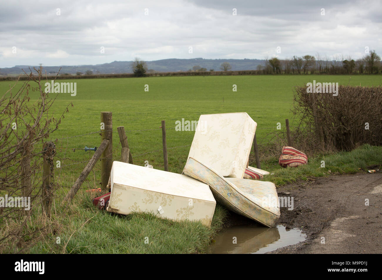 Mattresses and furniture dumped  in a lay-by near Gillingham, Dorset England UK GB Stock Photo
