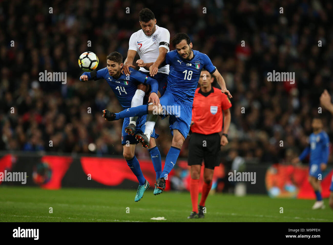 London, UK. 27th March, 2018. Alex Oxlade-Chamberlain of England © is squeezed between Italy's Jorge Luiz Jorginho (l) and Marco Parolo of Italy (r). Football International friendly, England v Italy at Wembley Stadium in London on Tuesday 27th March 2018.  Editorial Use Only pic by Andrew Orchard/Alamy Live news Stock Photo