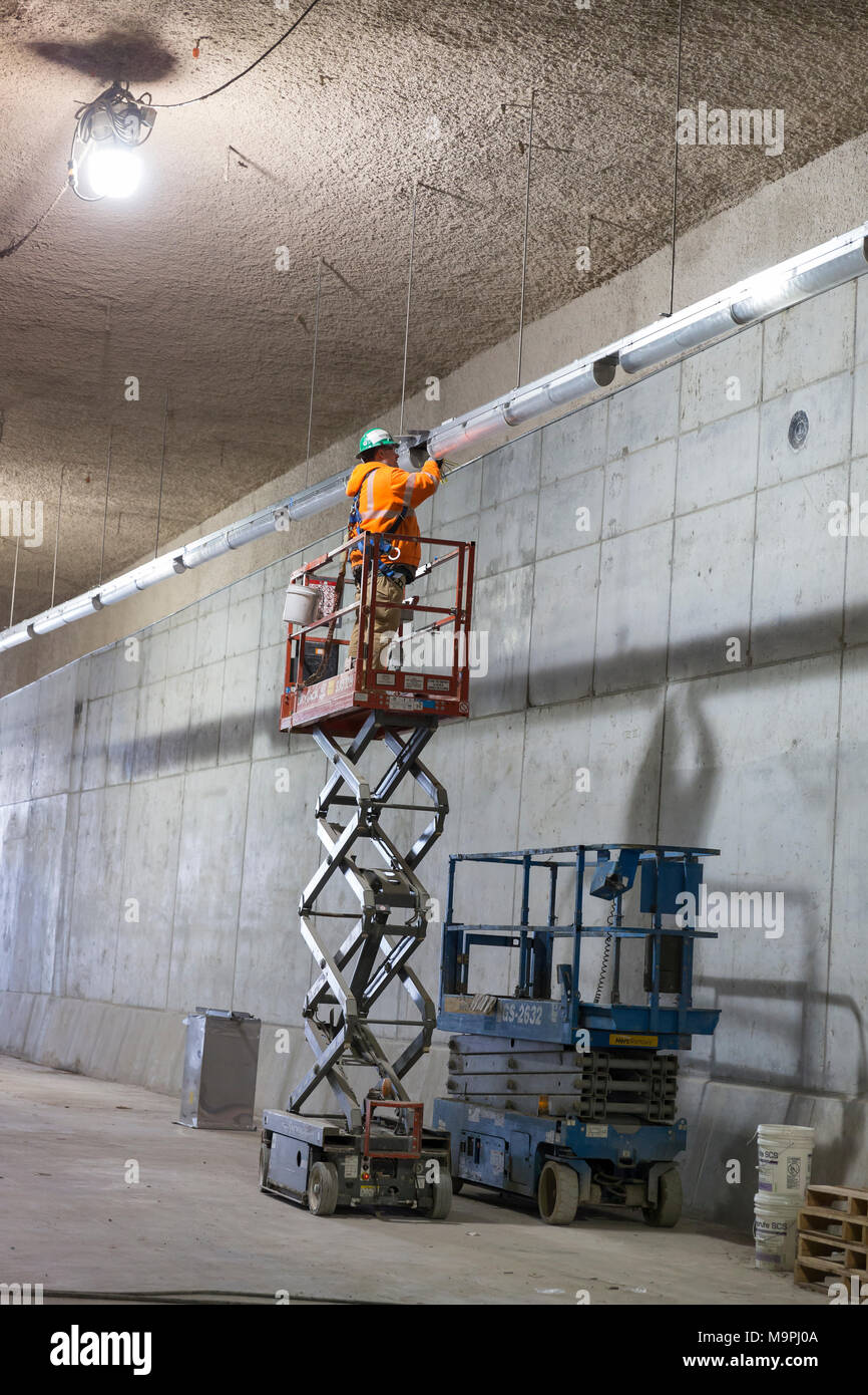 Seattle, Washington, USA. 27th Mar, 2018. Seattle Tunnel Partners' employee works on the lighting of the upper deck of the SR 99 Tunnel. The Alaskan Way Viaduct Replacement Program’s road decks have been completed and the tunnel’s operational and safety systems are currently being installed. The bored road tunnel is replacing the Alaskan Way Viaduct and will carry State Route 99 under downtown Seattle from the SODO neighborhood to South Lake Union. Credit: Paul Christian Gordon/Alamy Live News Stock Photo