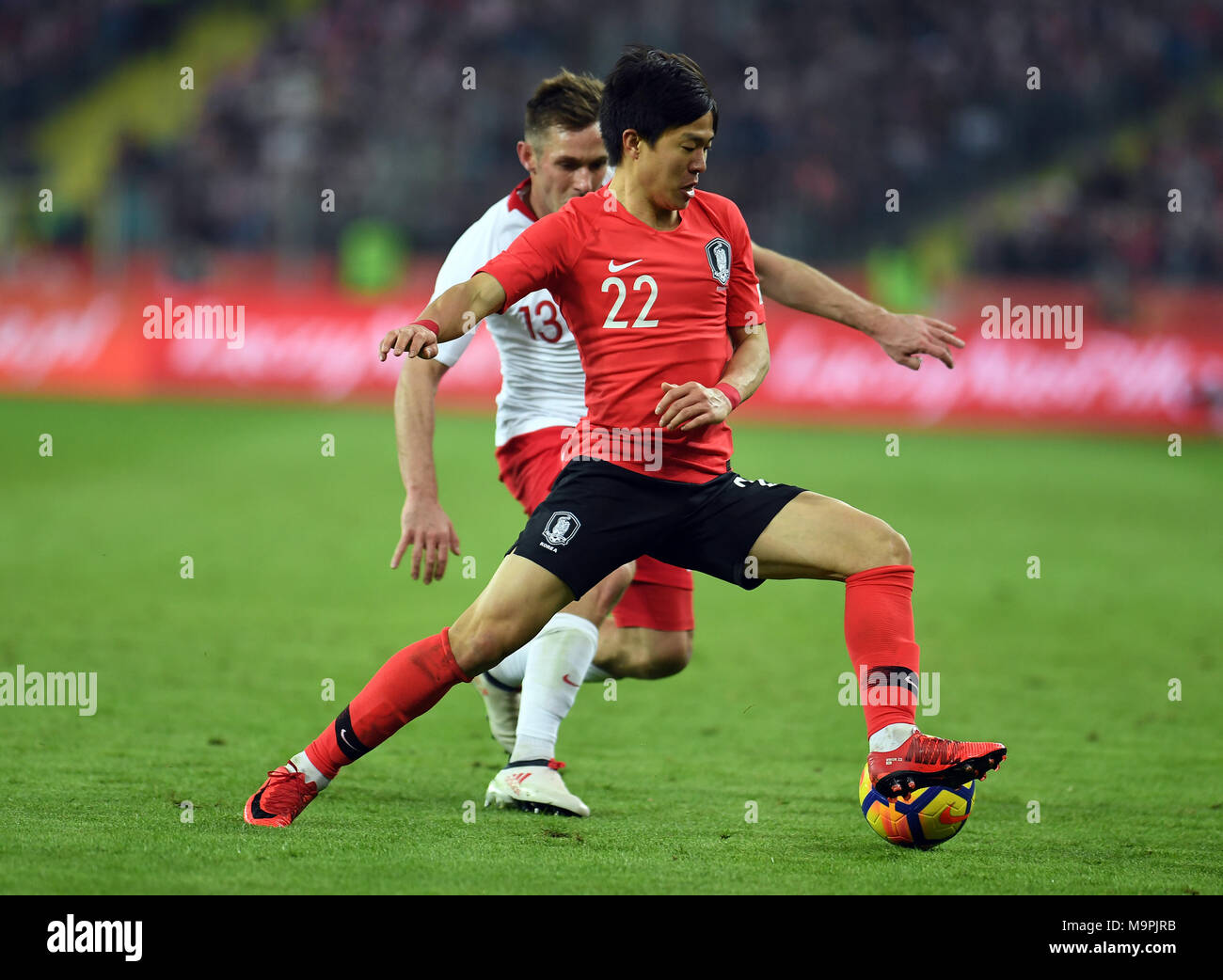 Chorzow, Poland. 27th Mar, 2018. Kwon Chang-hoon (Front) of South Korea vies with Maciej Rybus of Poland during a friendly match between Poland and South Korea in Chorzow, Poland, on March 27, 2018. Poland won 3-2. Credit: Maciej Gillert/Xinhua/Alamy Live News Stock Photo
