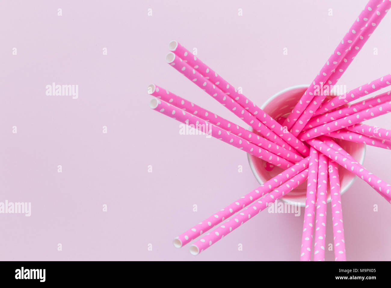 High angle view of paper cup with rose drinking straws polka design on ...