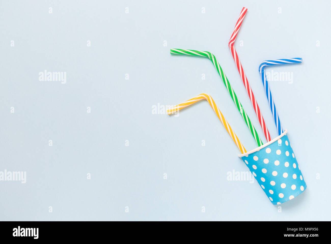 Flat lay of paper cup polka design with colorful drinking straws on ...