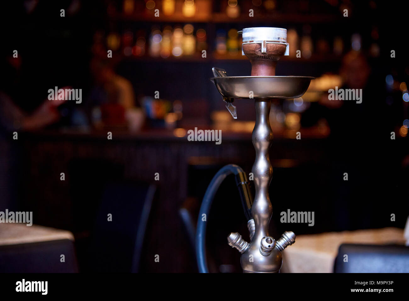 Hookah on a dark background of a blurry bar with a bokeh Stock Photo