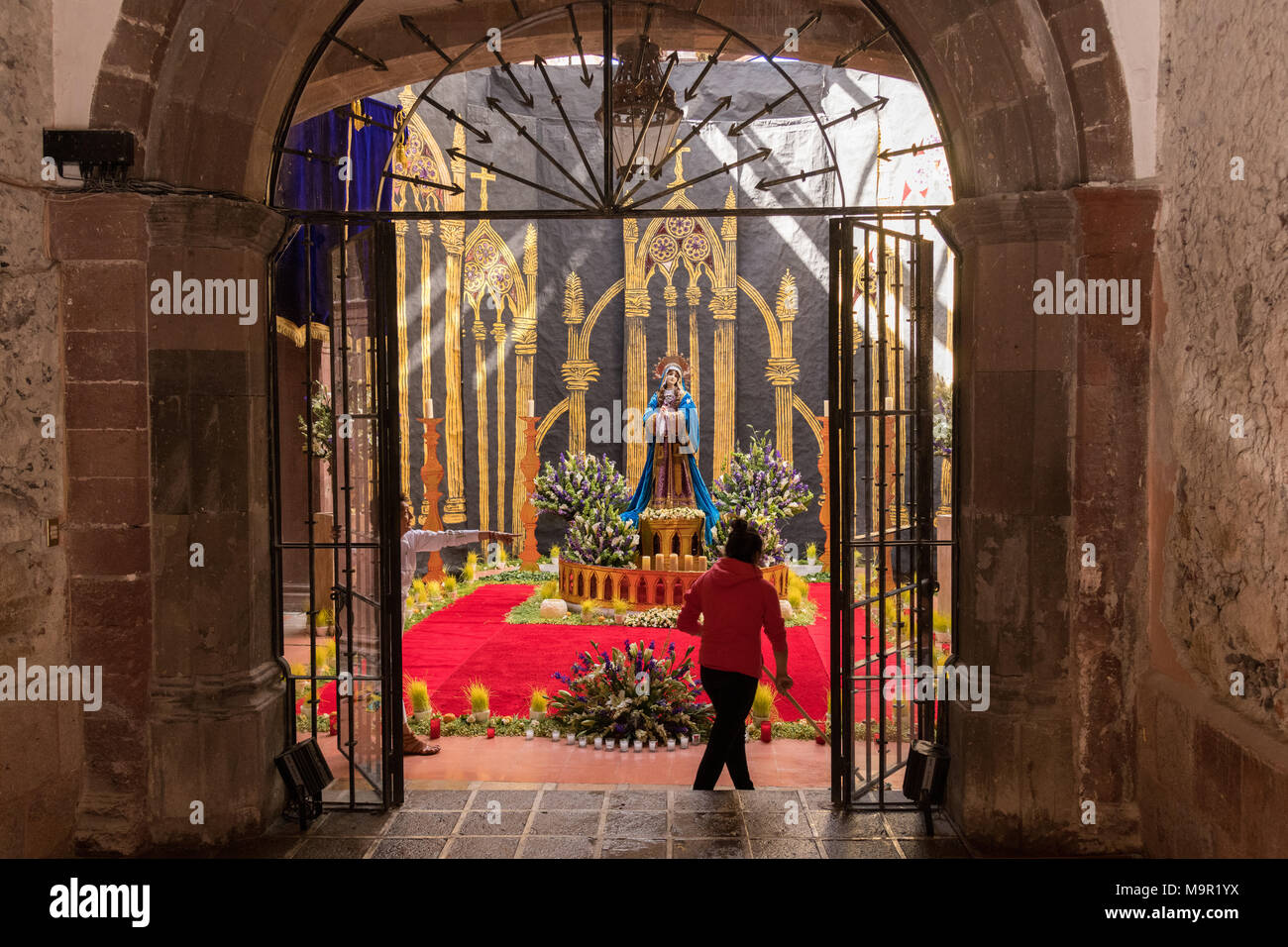 A Mexican woman prepares an altar celebrating El Viernes de Dolores during Holy Week March 23, 2018 in San Miguel de Allende, Mexico. The event honors the sorrow of the Virgin Mary for the death of her son and is an annual tradition in central Mexico. Stock Photo