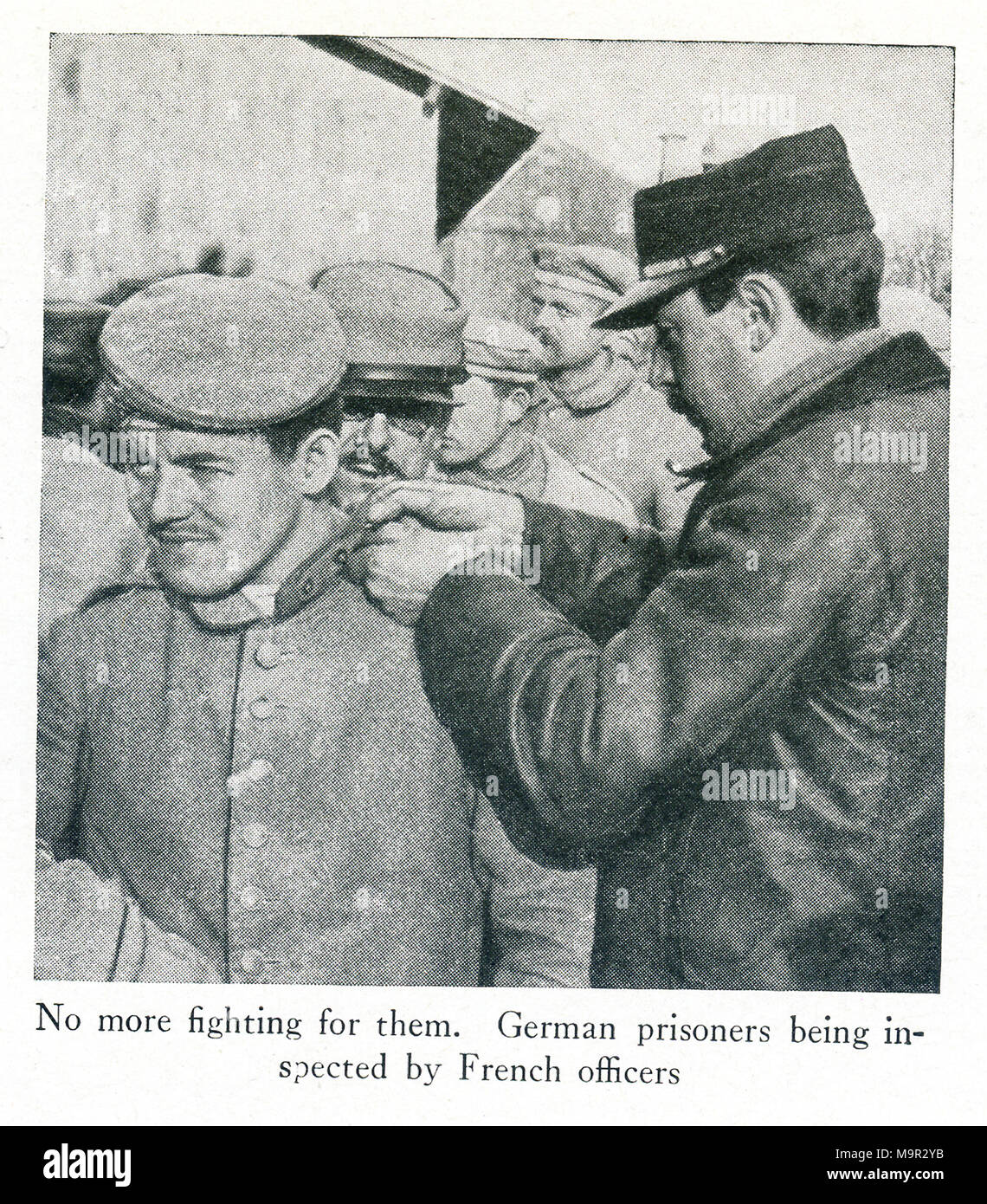 This photo dates to World War I and shows German prisoners. The caption says: No more fighting for them. German prisoners being inspected by French officers. Stock Photo
