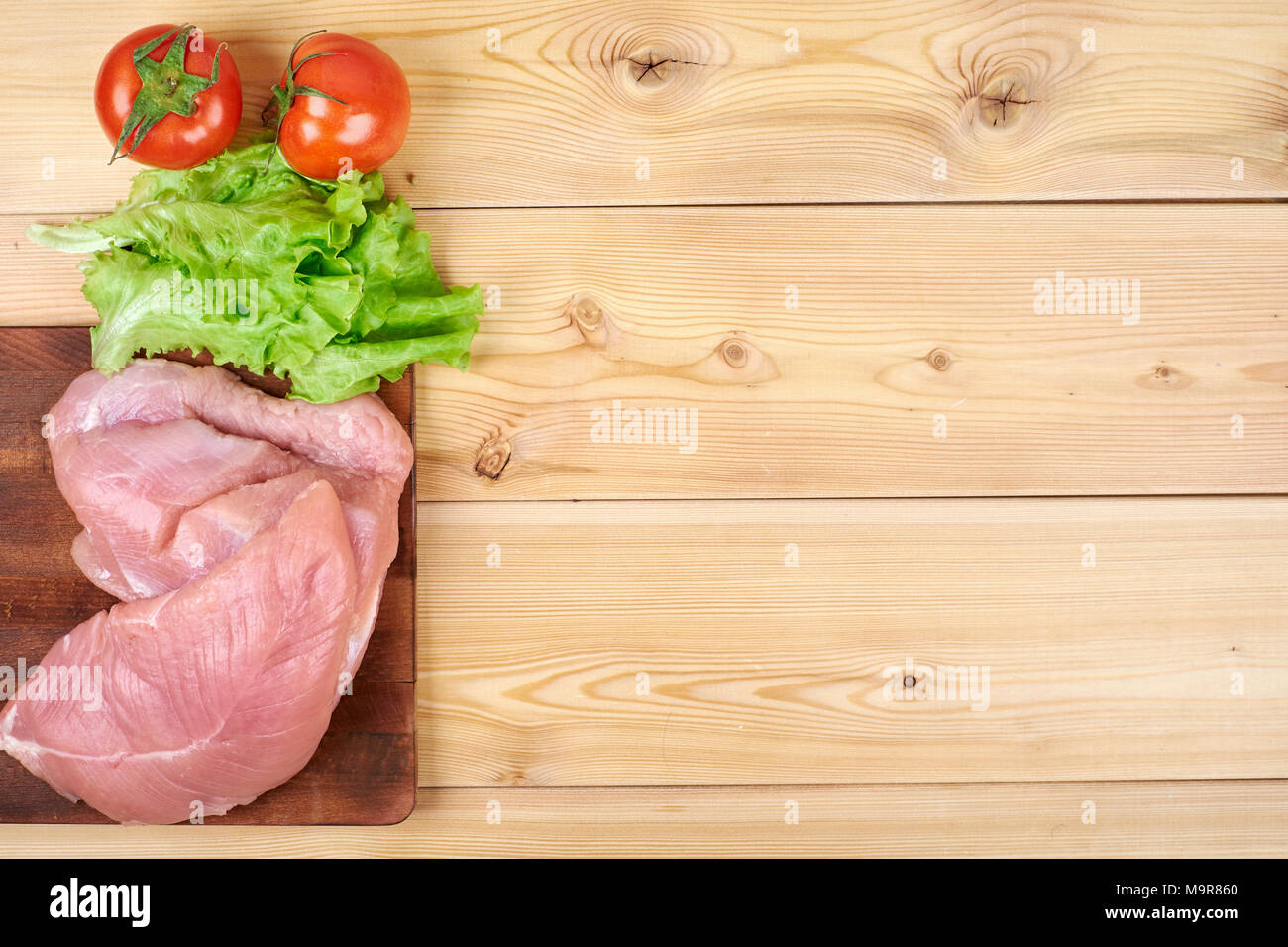 Fresh vegetables and dietary meat on wooden background. Healthy natural food on table with copy space. Cooking ingredients top view, mockup for recipe or menu Stock Photo