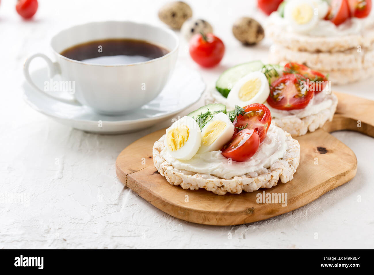 Open sandwiches of rice cakes with cream cheese , vegetables and quail egg, healthy breakfast