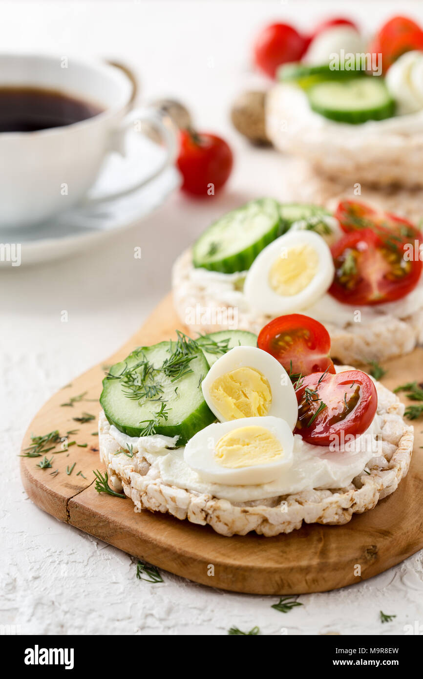 Open sandwiches of rice cakes with cream cheese , vegetables and quail egg, healthy breakfast