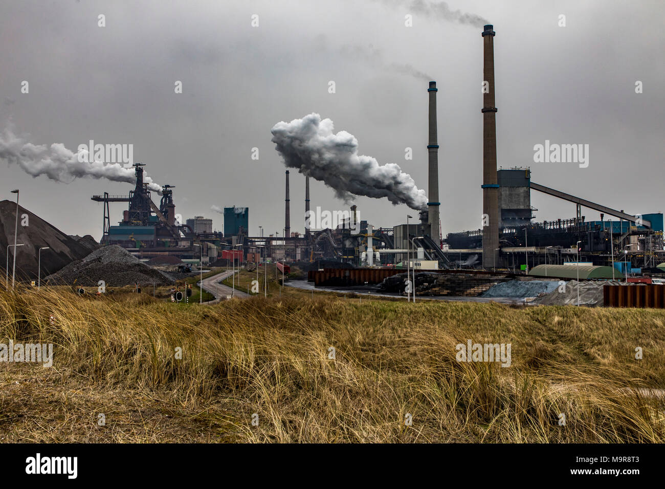 Factory Tata Steel with smoking chimneys on a sunny day, IJmuiden, The  Netherlands Stock Photo