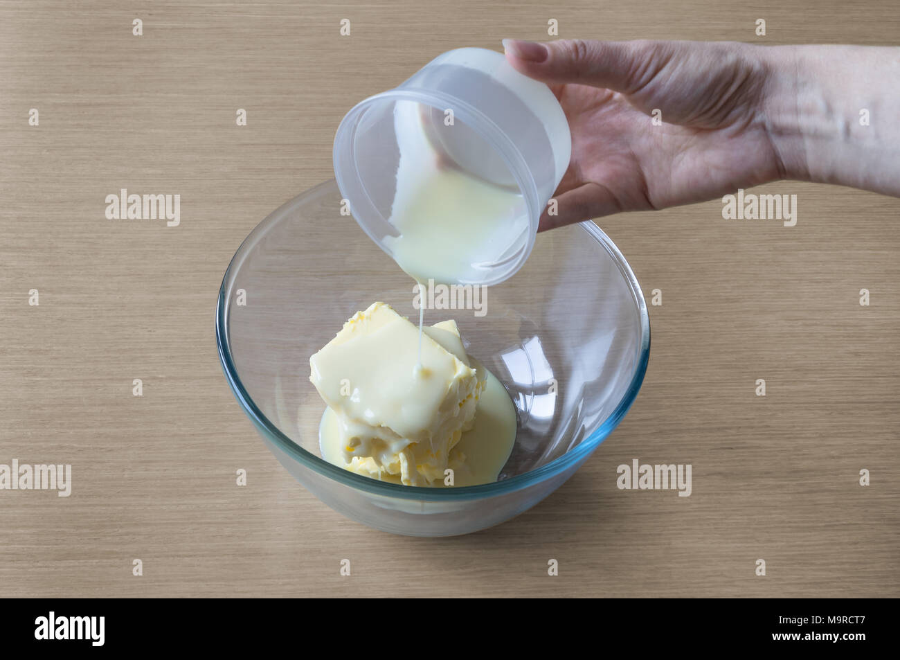 Adding ingredients condensed milk and butter in the bowl for cooking