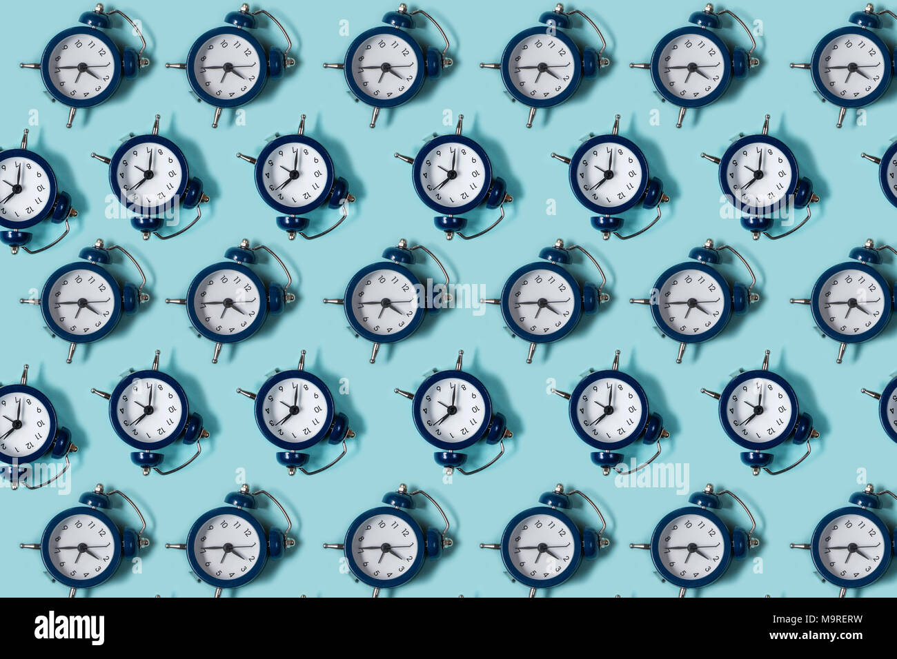 Flat lay retro beautiful new alarm clock on blue color background ...