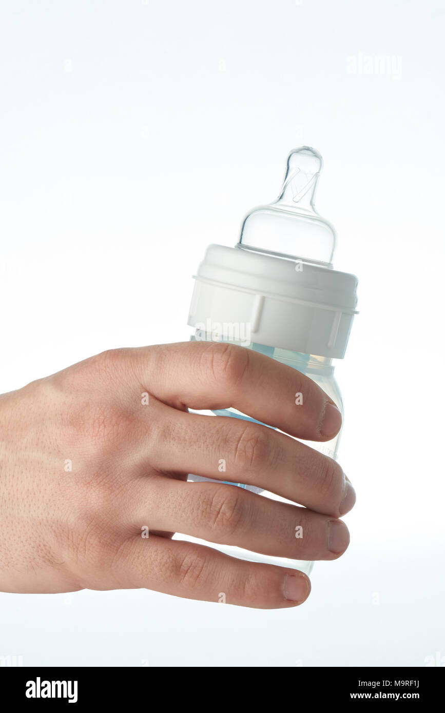Feeding baby bottle close-up in hand isolated on white background Stock Photo