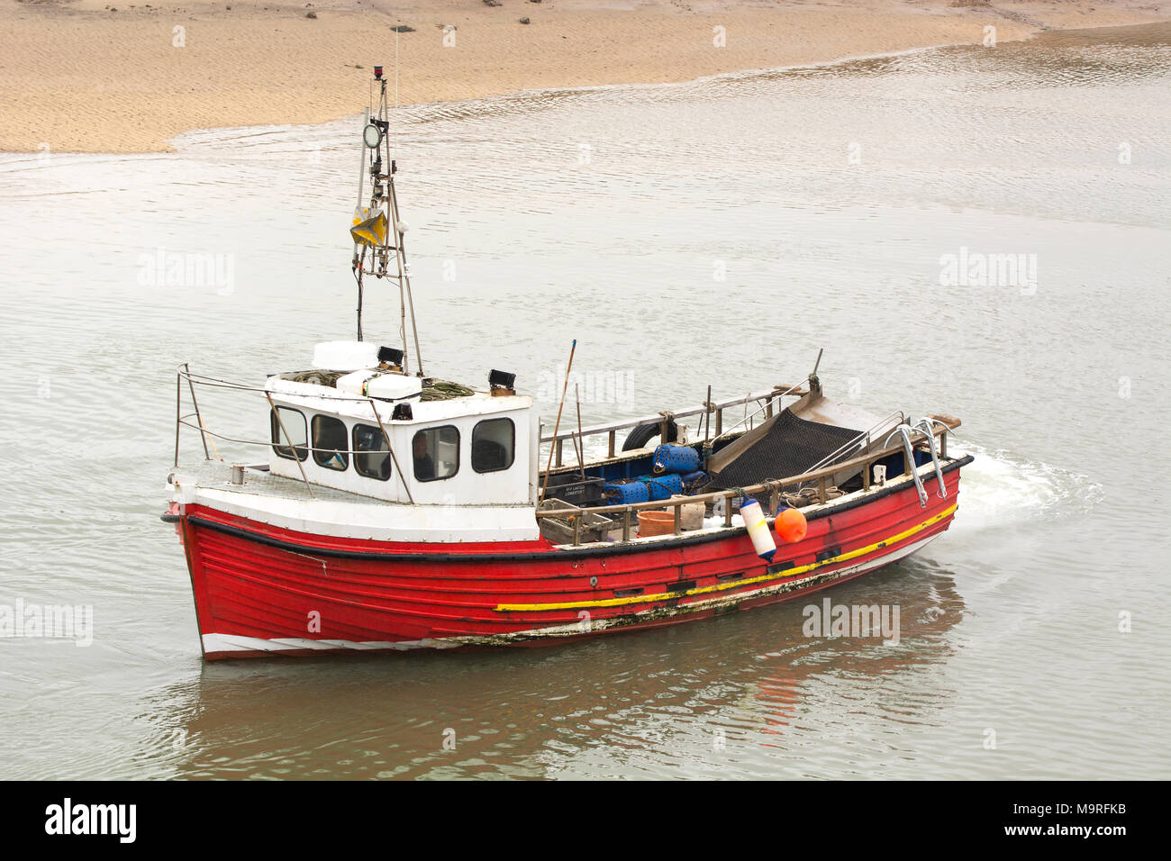 Small red fishing boat near the shore Stock Photo - Alamy