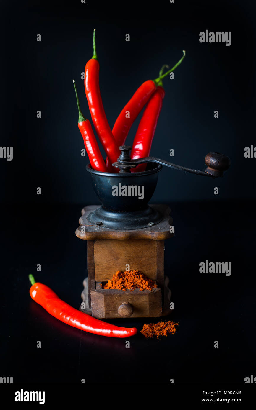 ground red pepper, grinder and paprikar on a black background Stock