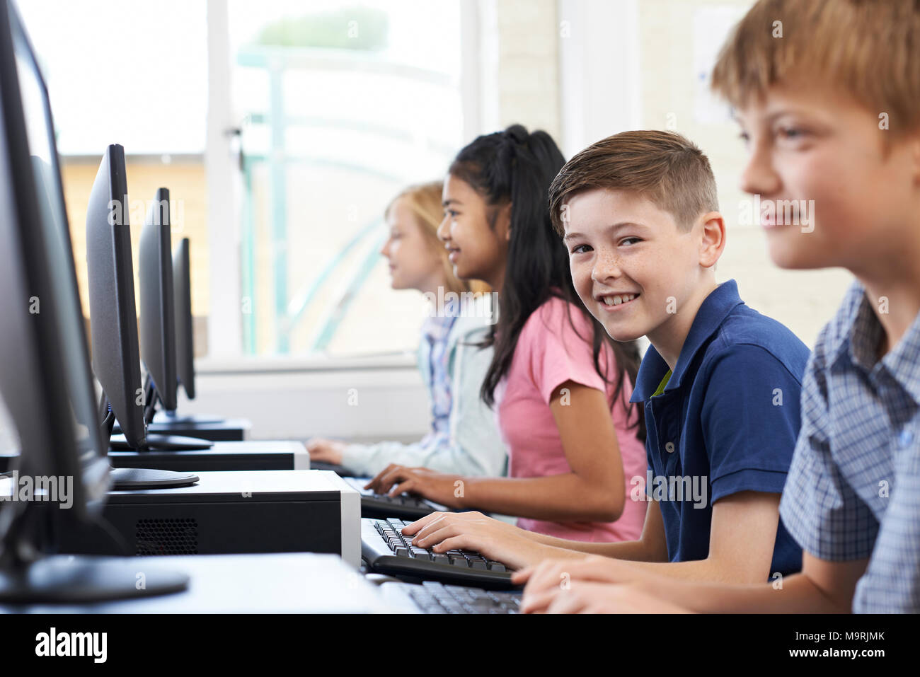 Portrait Of Line Of Elementary Pupils In Computer Class Stock Photo