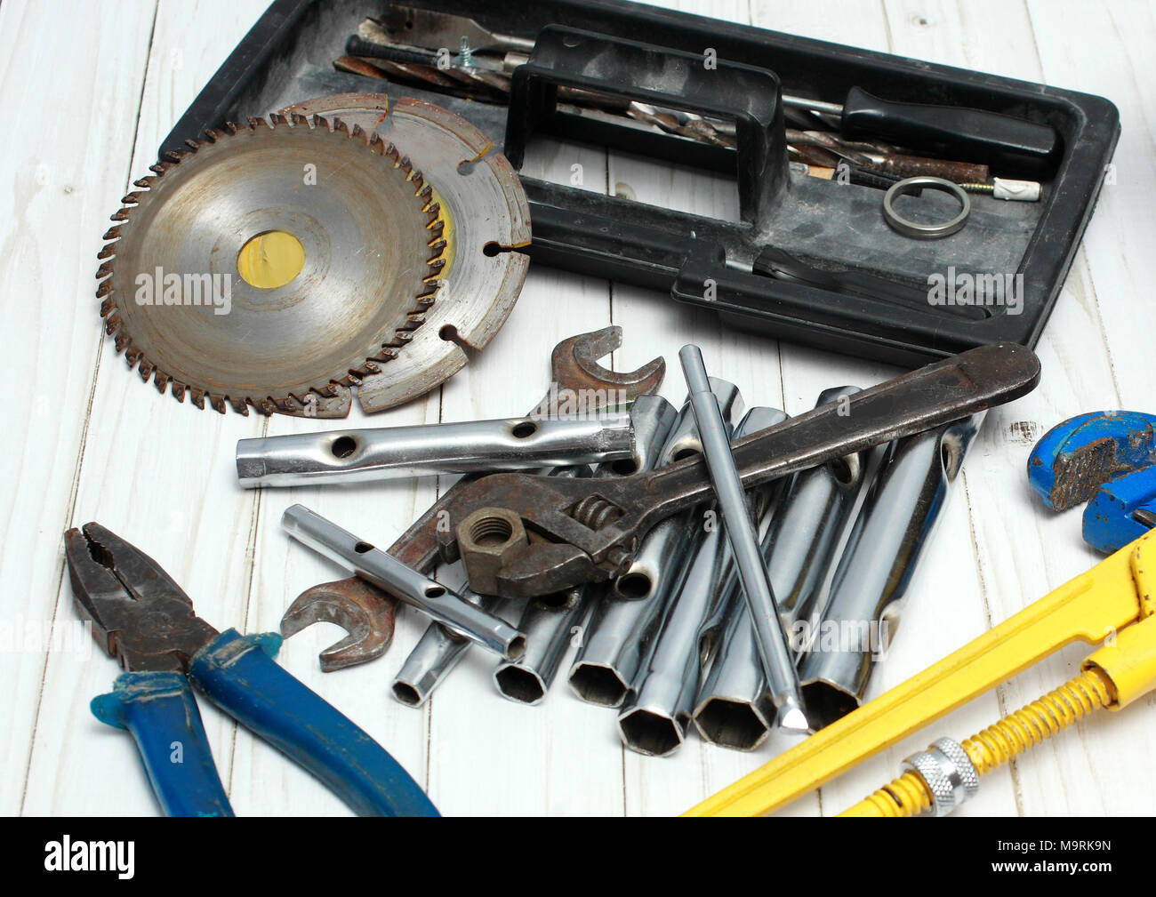 Screwdrivers, wrenches and disks lie on a wooden table. Stock Photo