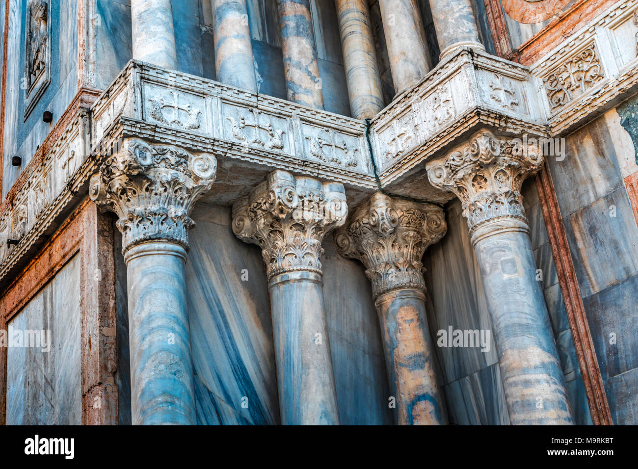 Corinthian columns and panels of decorative blue marble on the north facade of St Marks Basilica in Venice, in the Piazzetta dei Leoncini Stock Photo