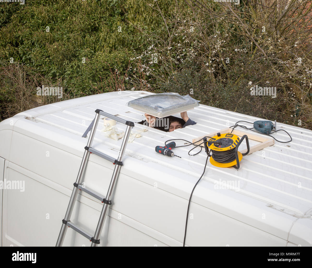 Cutting through roof of white metal camper van conversion to install Dometic roof light