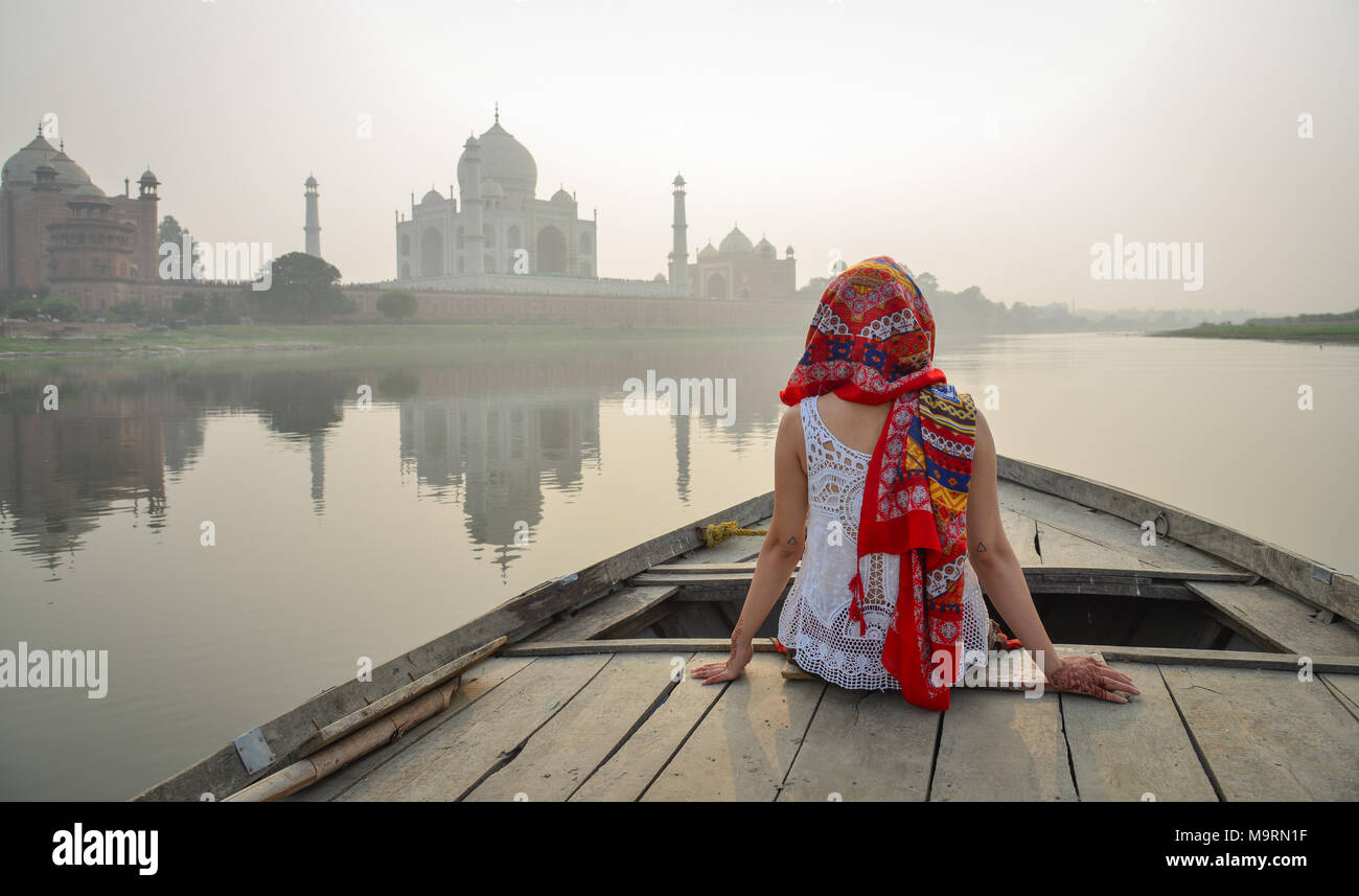 A young woman watching sunset over Taj Mahal from a wooden boat. Stock Photo