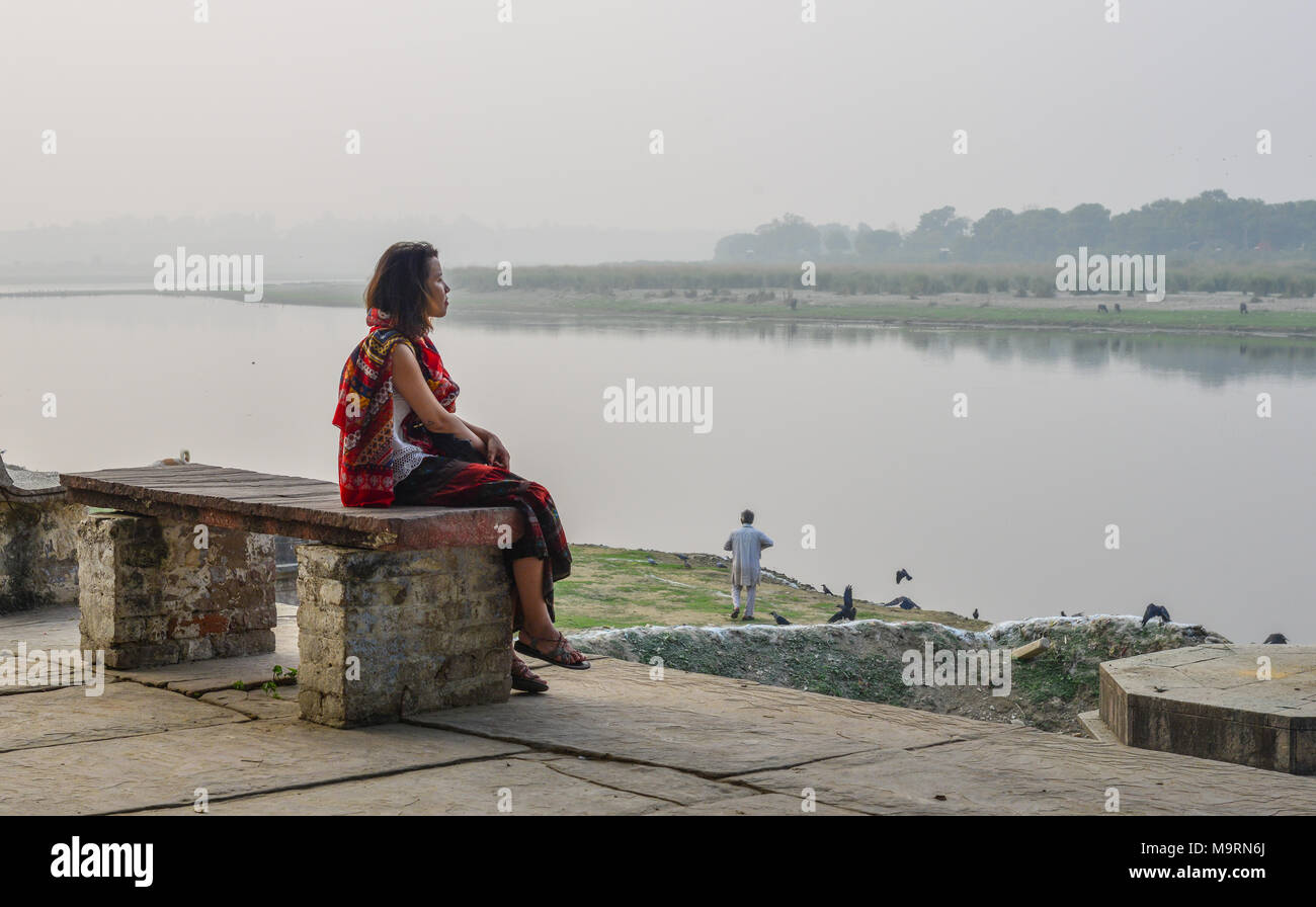 Woman enjoys sitting and relaxing at the riverbank Stock Photo - Alamy