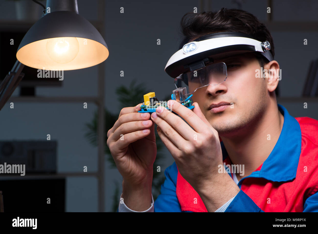 Computer specialist repairing PC late at night Stock Photo - Alamy